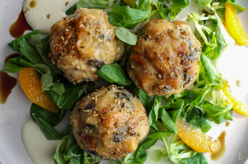 Brezenknödel mit Kürbiskernen auf Feldsalat und Orangenfilets